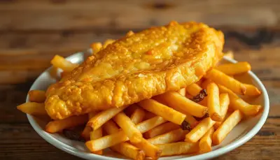 Battered fried fish fillets with a golden crust, served with thick-cut chips.